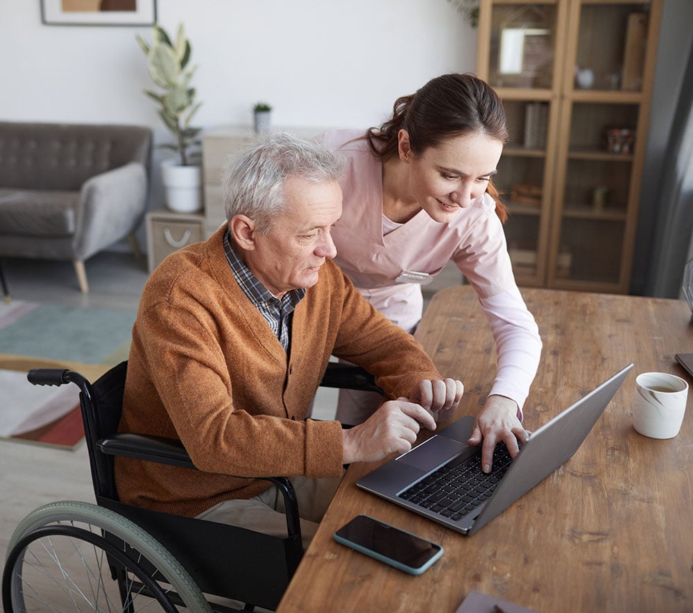 Caregiver working with patient at computer